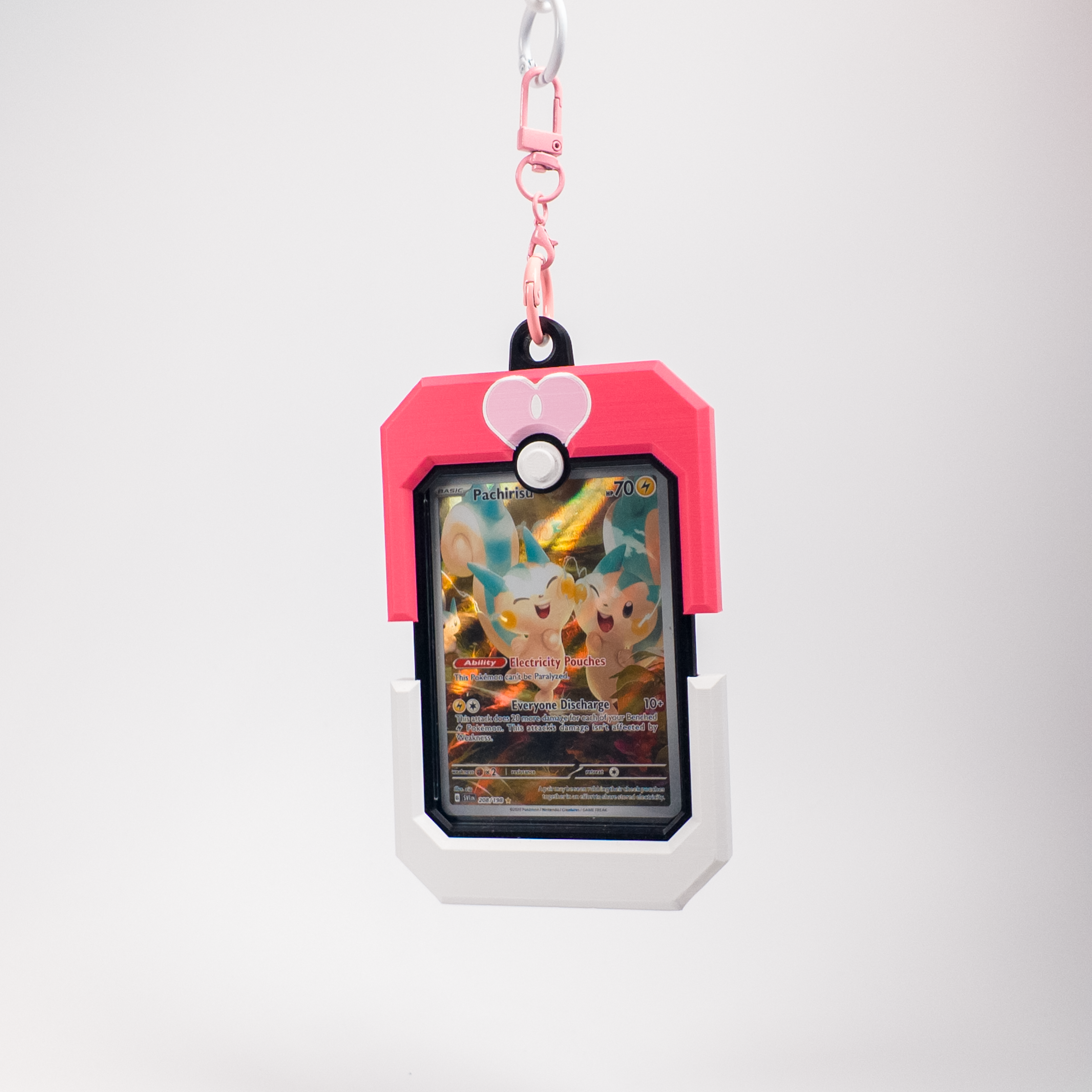 A pink and white Pokémon-themed card holder or pouch with a clasp at the top, holding a Pokémon card featuring Eevee. The product is photographed against a clean, light gray studio background.