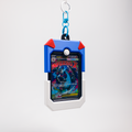 A blue and white card holder keychain case with red corner accents, holding a colorful 'Inferno X' trading card, suspended from a blue and silver carabiner on a light gray background.