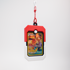 A red and white Pokémon Trainer Badge keychain holding a holographic Eevee card, suspended from a red chain and silver carabiner on a light gray background.
