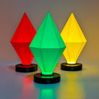Three geometric lampshades in red, green, and yellow on a reflective surface with a gradient background.