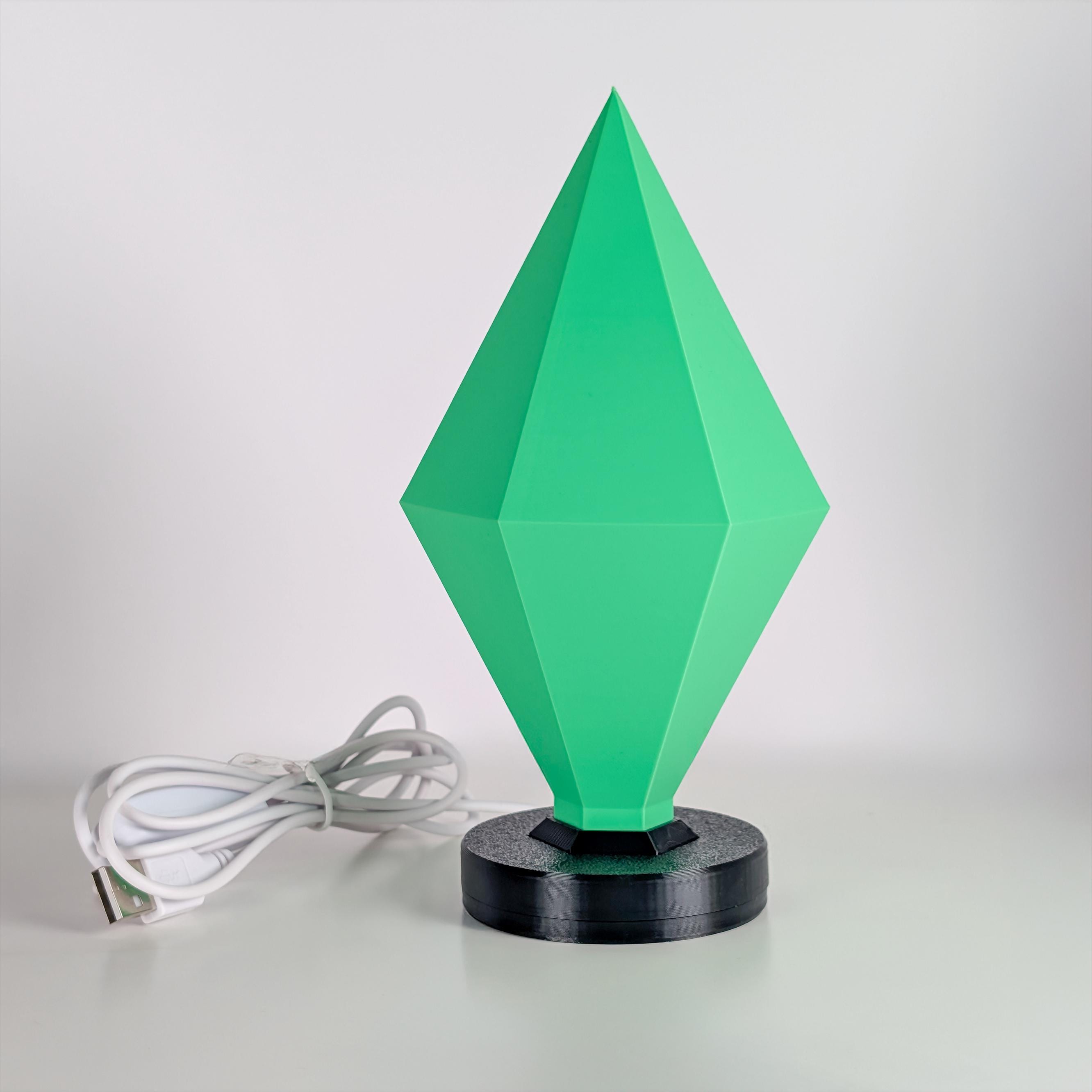 Green geometric lamp with a black base on a white background